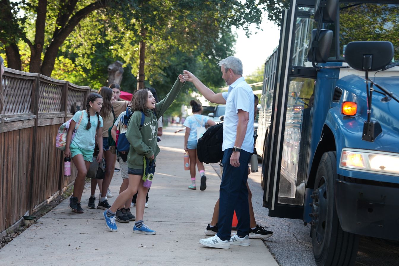 Grae Baker, Head of School, greeting a student at the bus