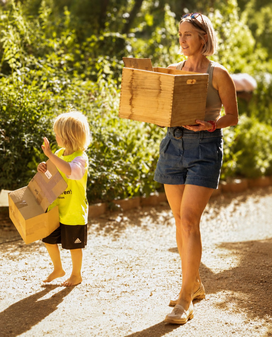 A parent and child on the AMS grounds, each carrying their own load