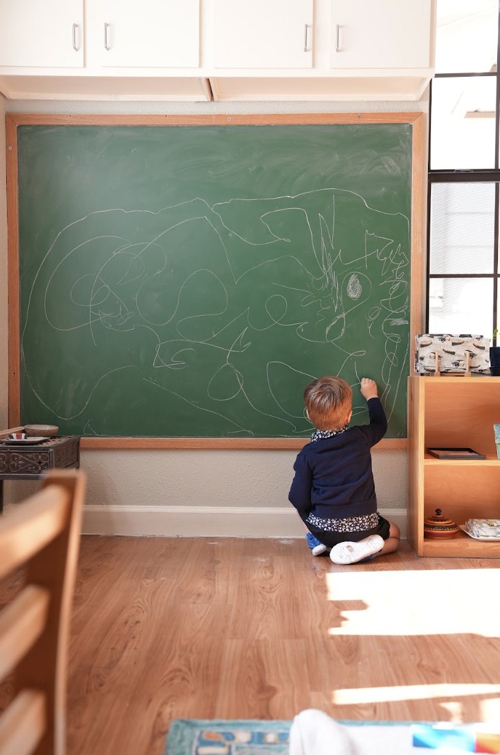 A child drawing at a chalkboard